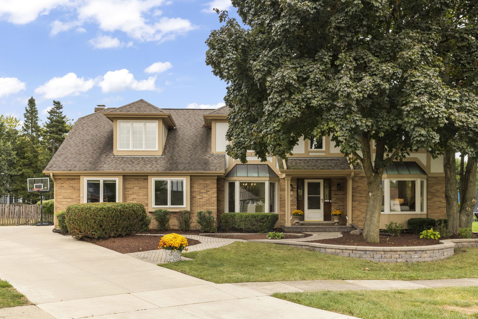 a front view of a house with outdoor seating and covered with trees