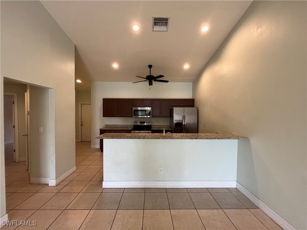 a large white kitchen with a sink a microwave and cabinets