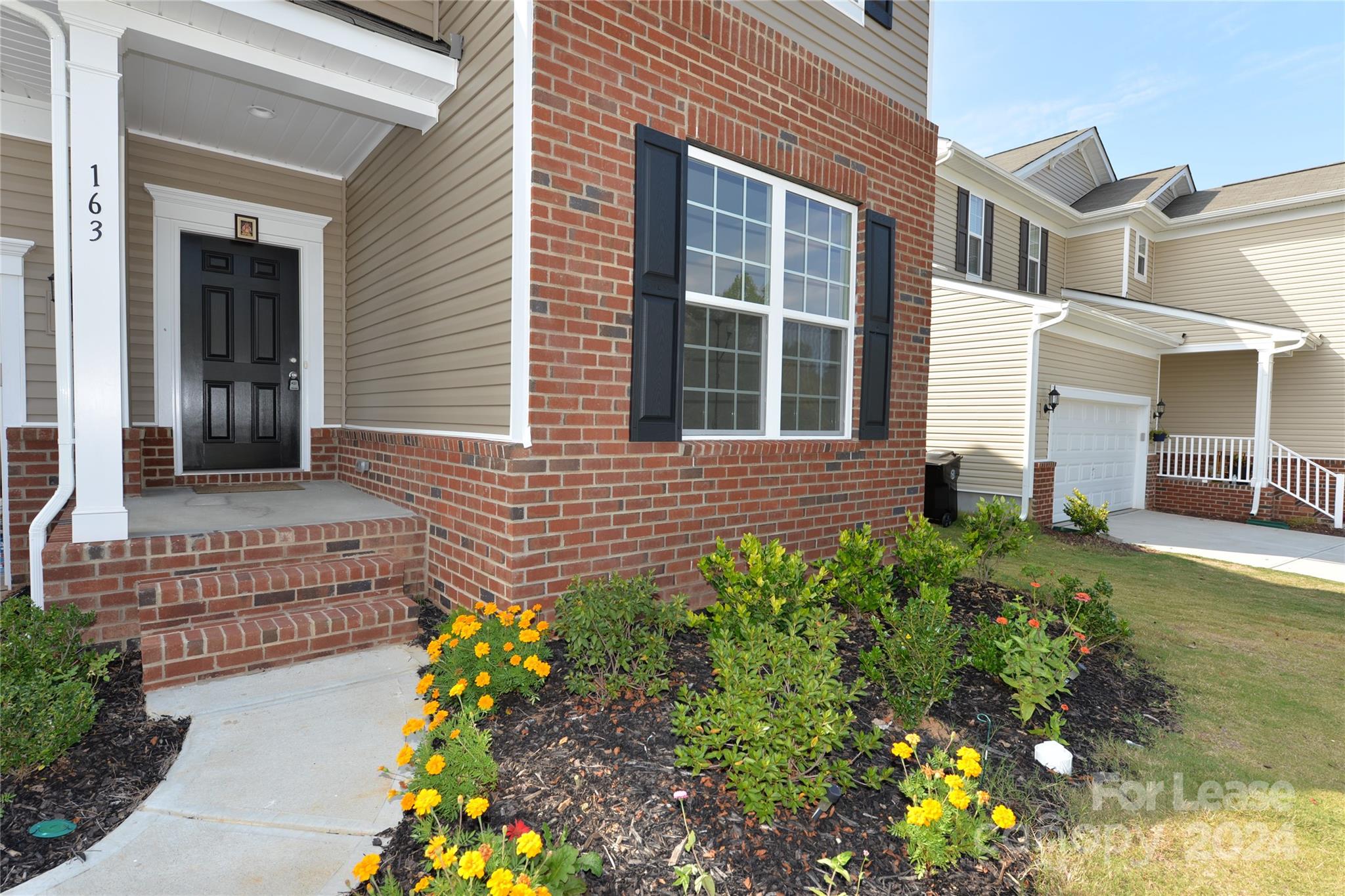 a front view of a house with a garden