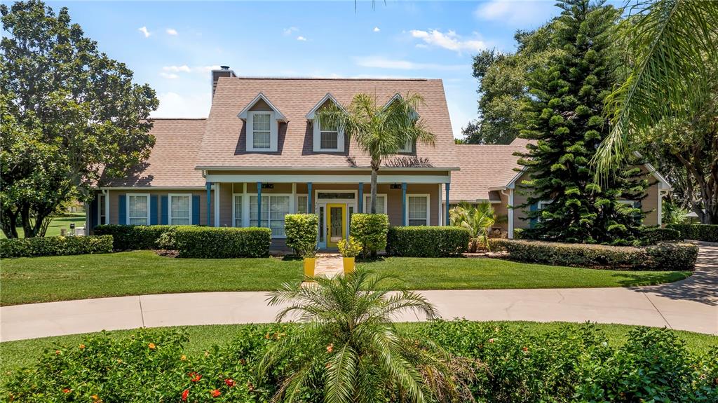 a front view of a house with a yard and potted plants