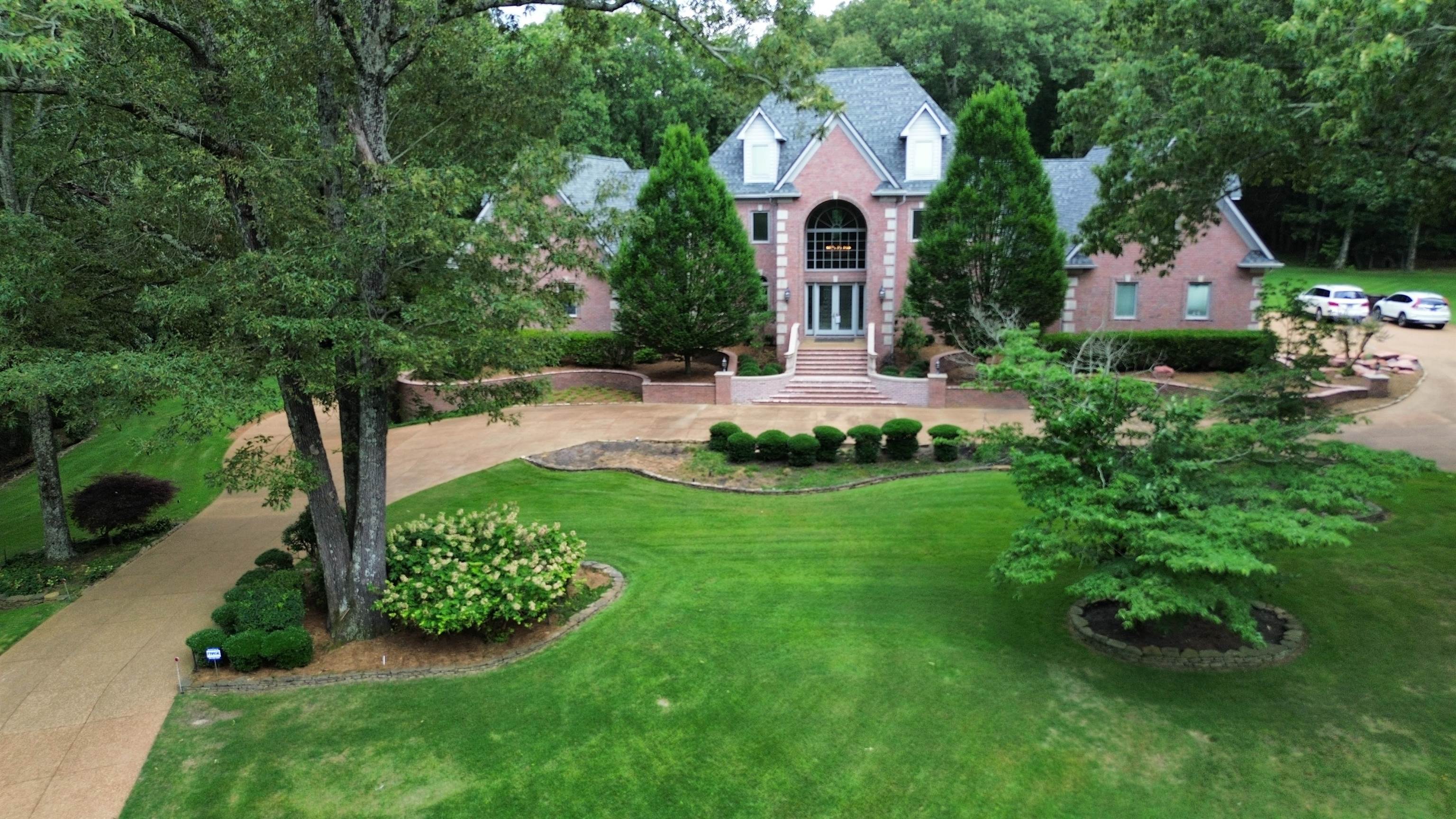 a front view of a house with a yard and trees