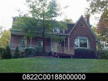 a view of a yard in front of a house with large windows