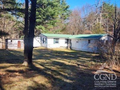 a view of a house with backyard and trees