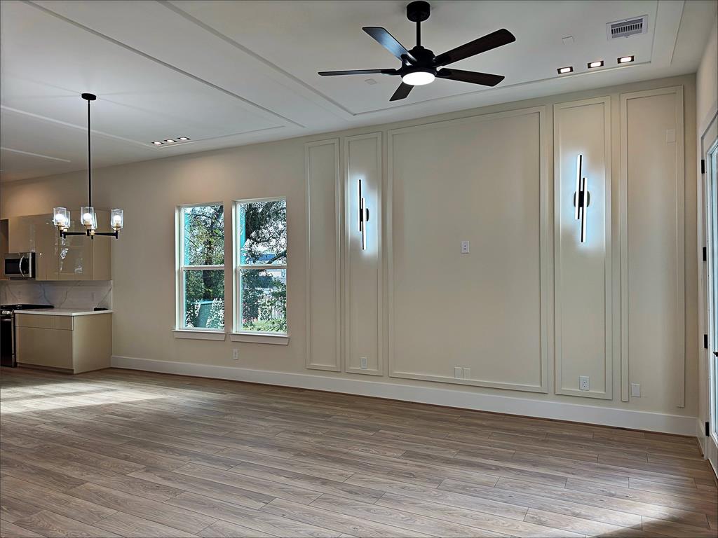 a view of an empty room with window and wooden floor