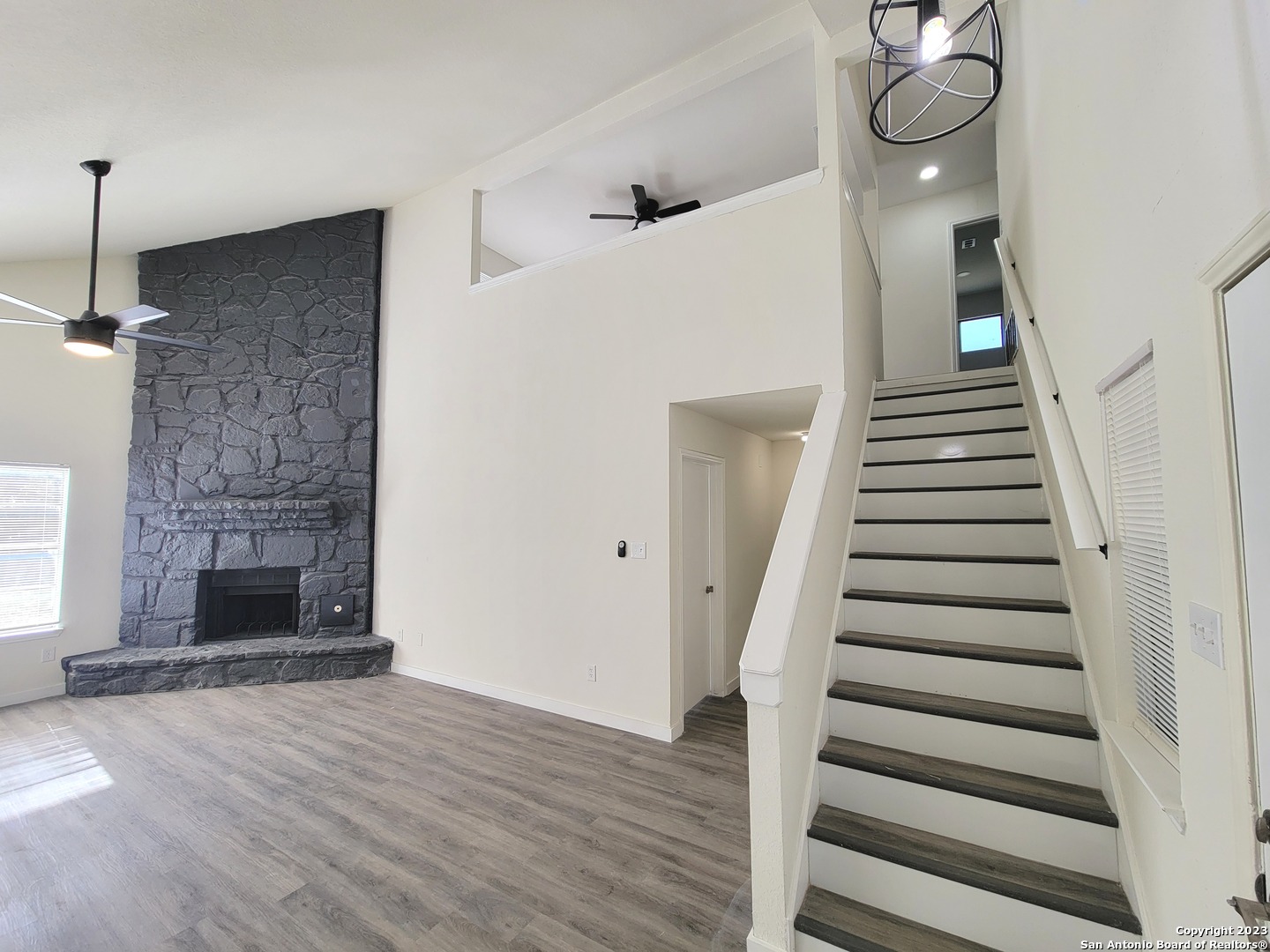 a view of a livingroom with wooden floor and stairs