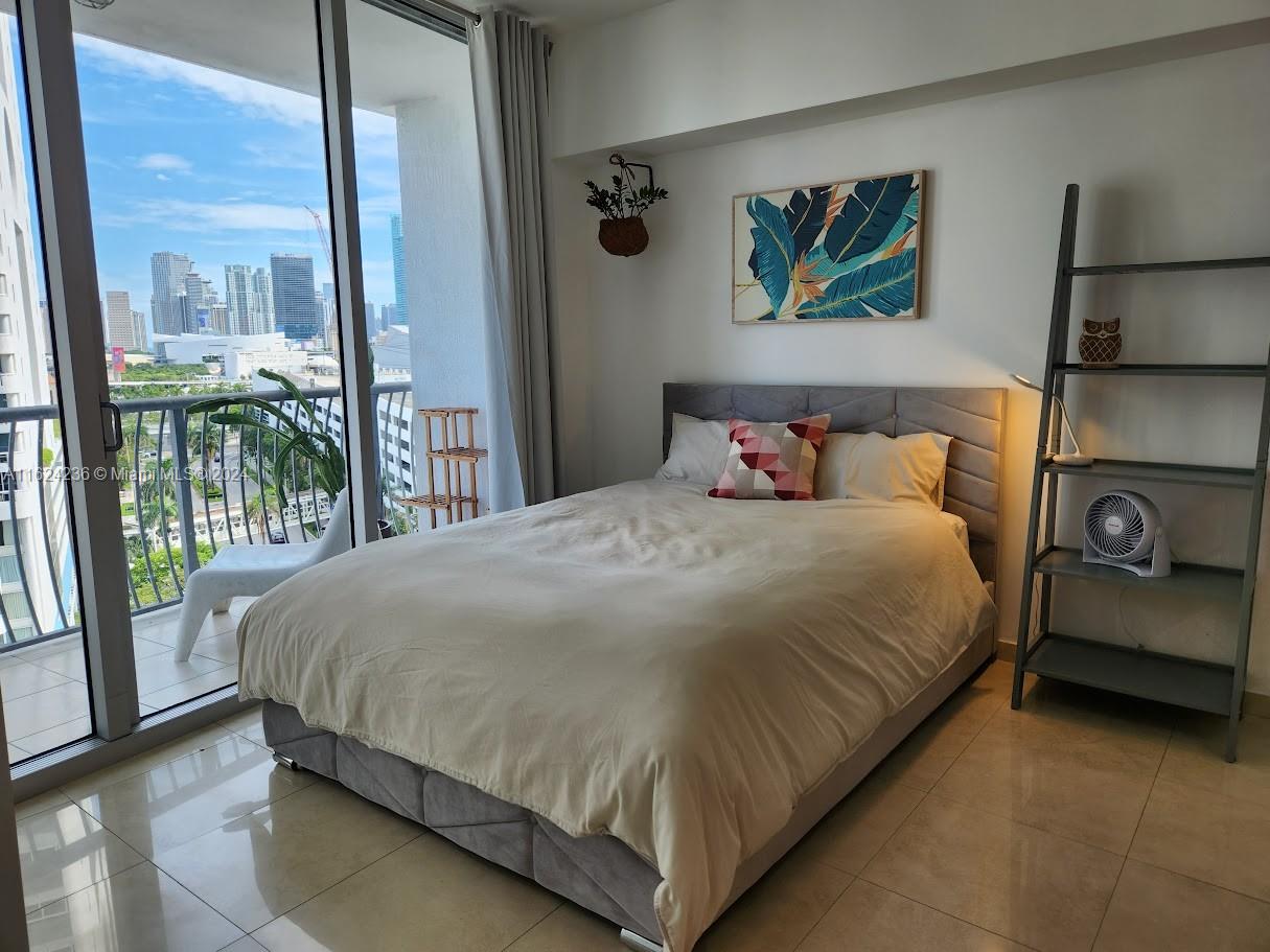 a bedroom with a large bed and a painting on the wall