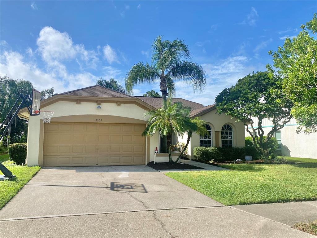 a front view of a house with a garden and palm trees