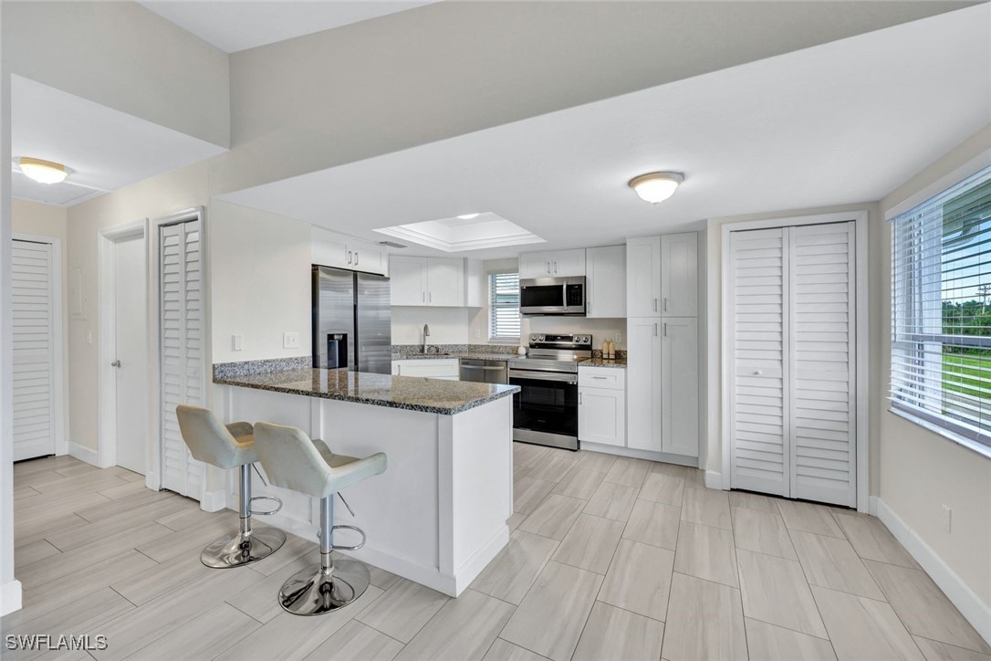 a kitchen with stainless steel appliances a stove a sink cabinets and wooden floor