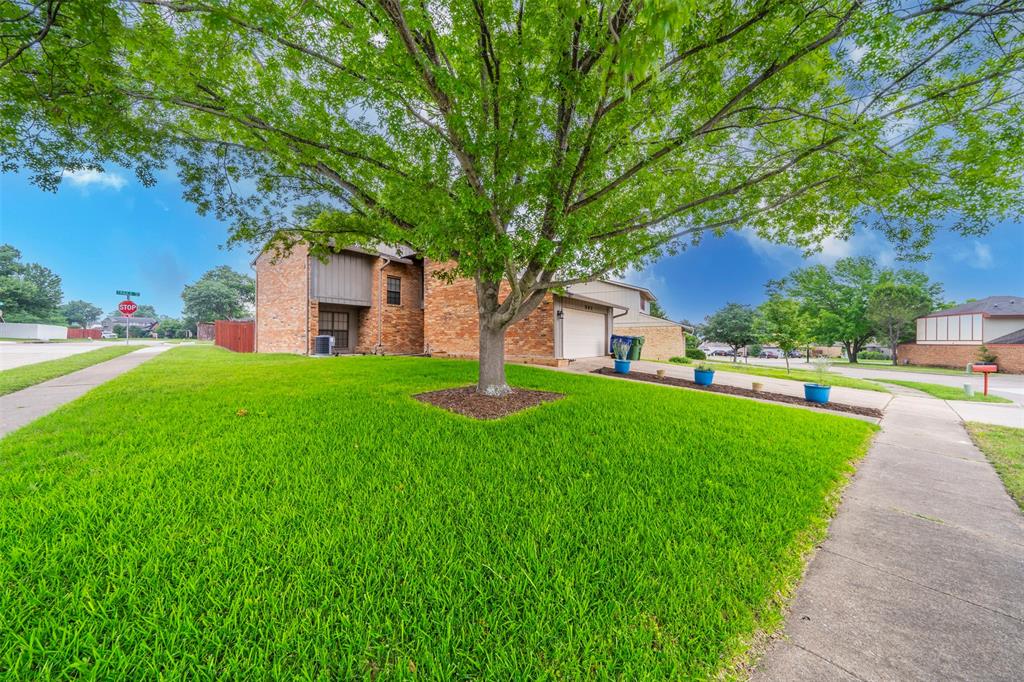 a front view of a house with a yard and trees