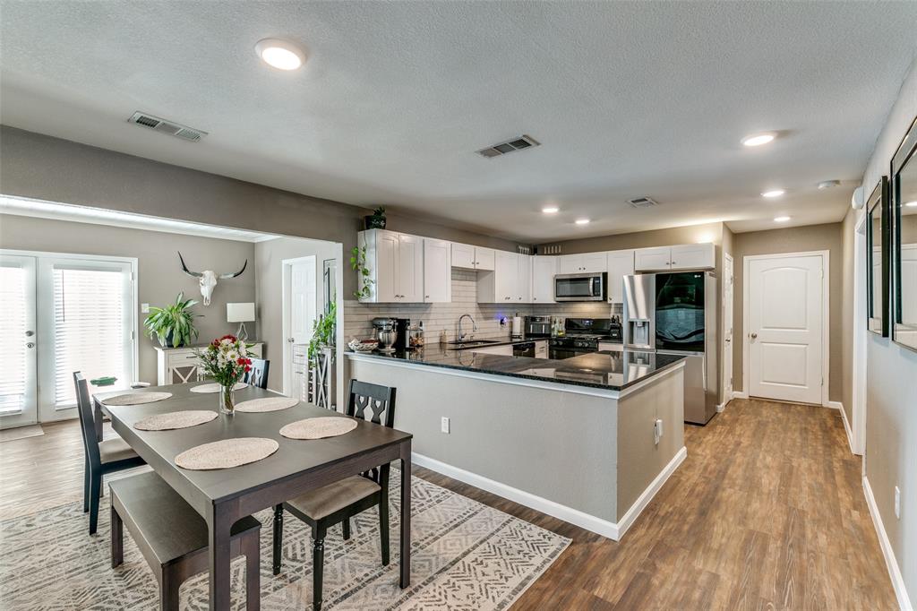 a kitchen with kitchen island granite countertop lots of counter top space and stainless steel appliances