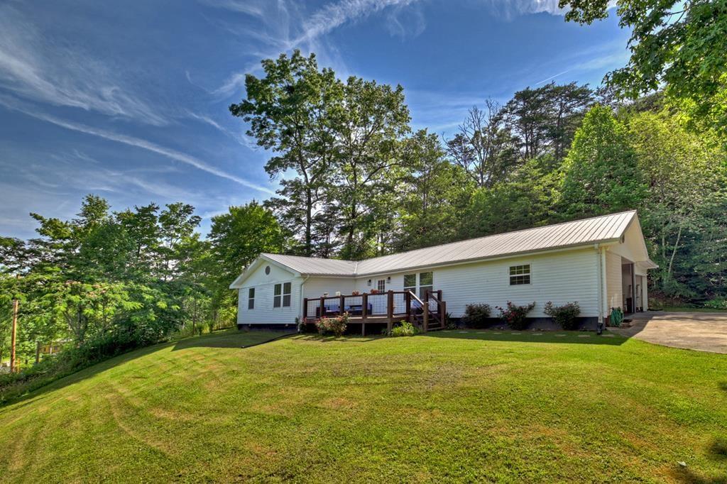 a front view of house with yard and trees in the background