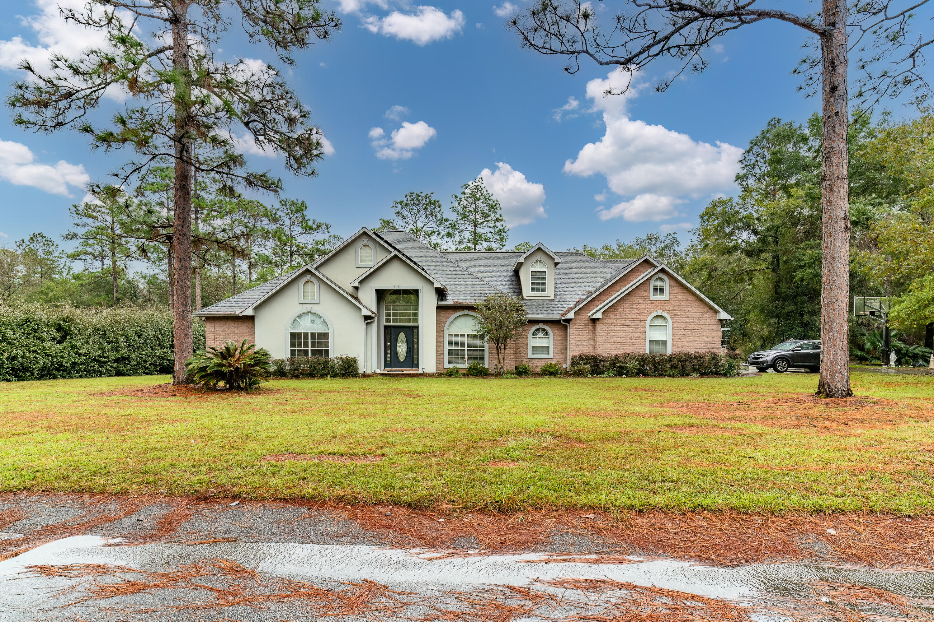 a front view of a house with a garden and trees