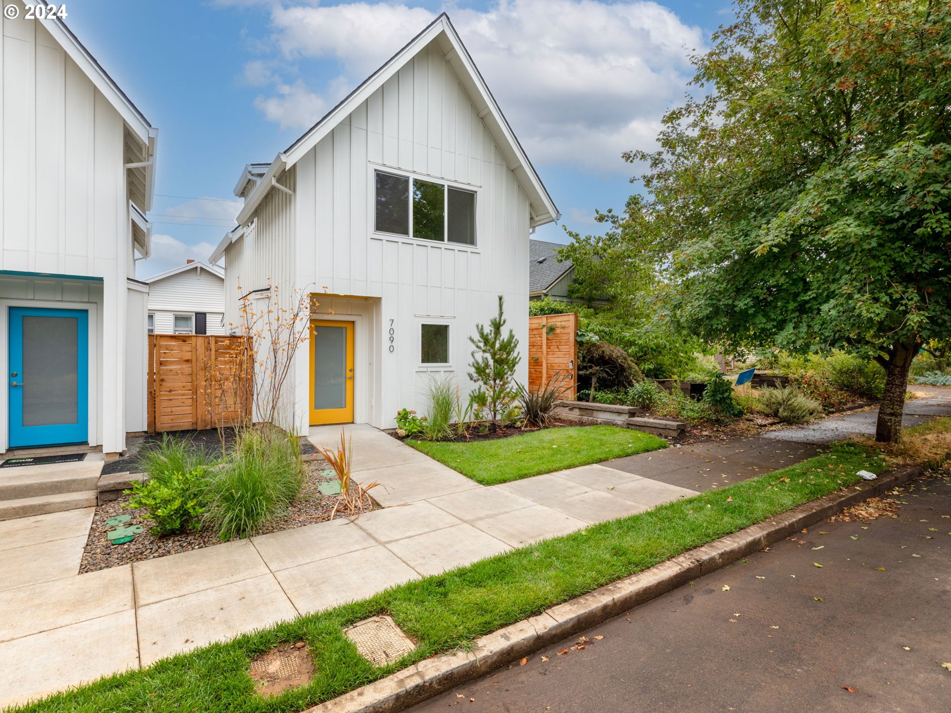 a front view of a house with a yard and potted plants