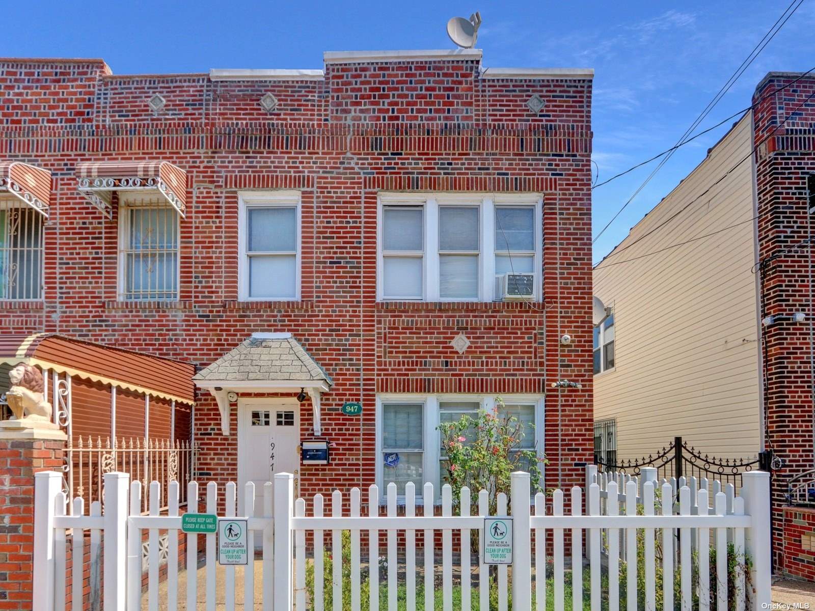 front view of a brick house with a fence