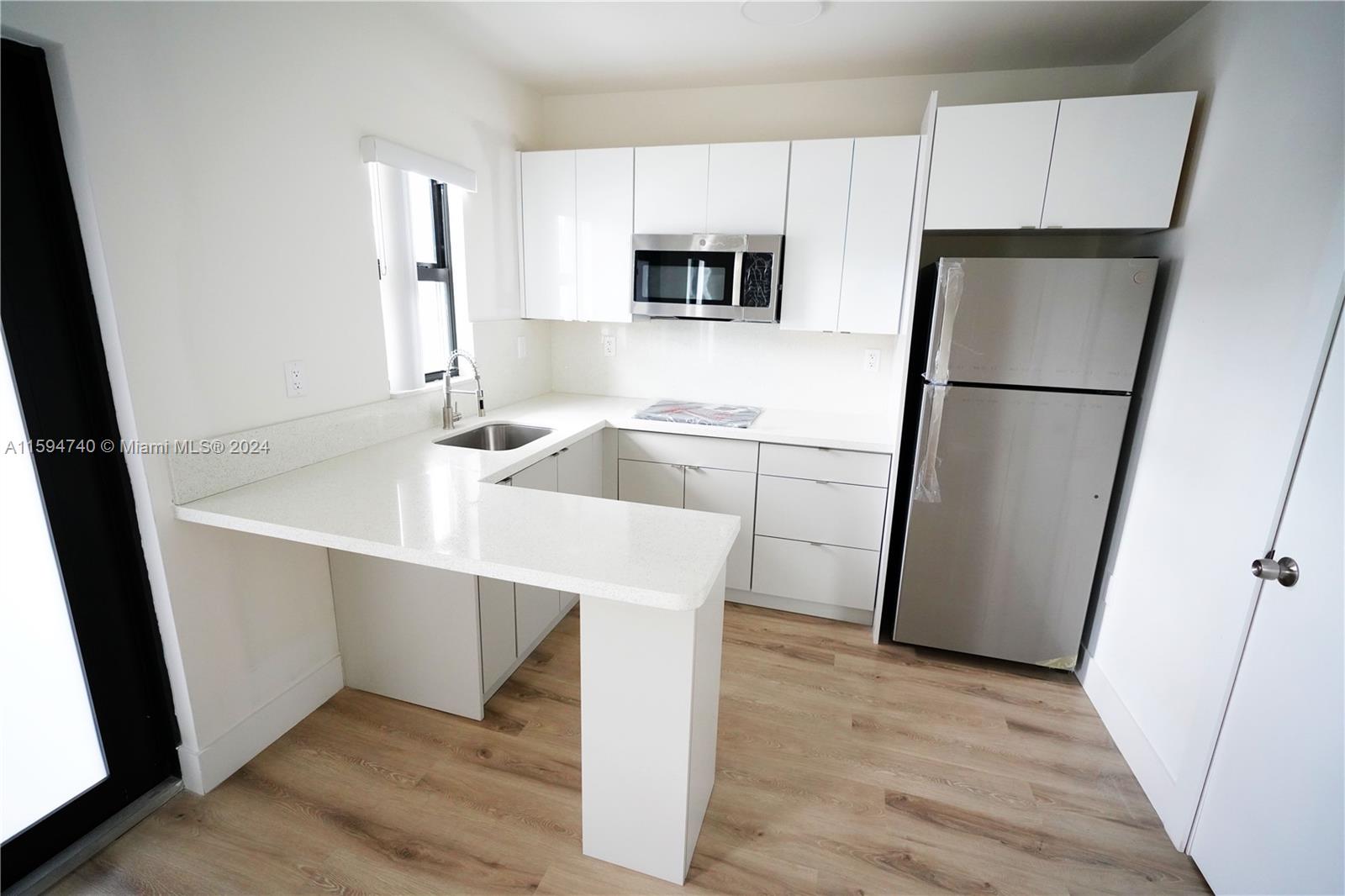 a kitchen with stainless steel appliances a refrigerator sink and microwave