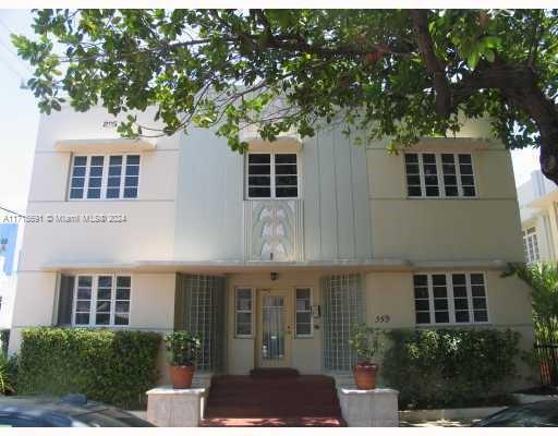 a front view of a building with a garden