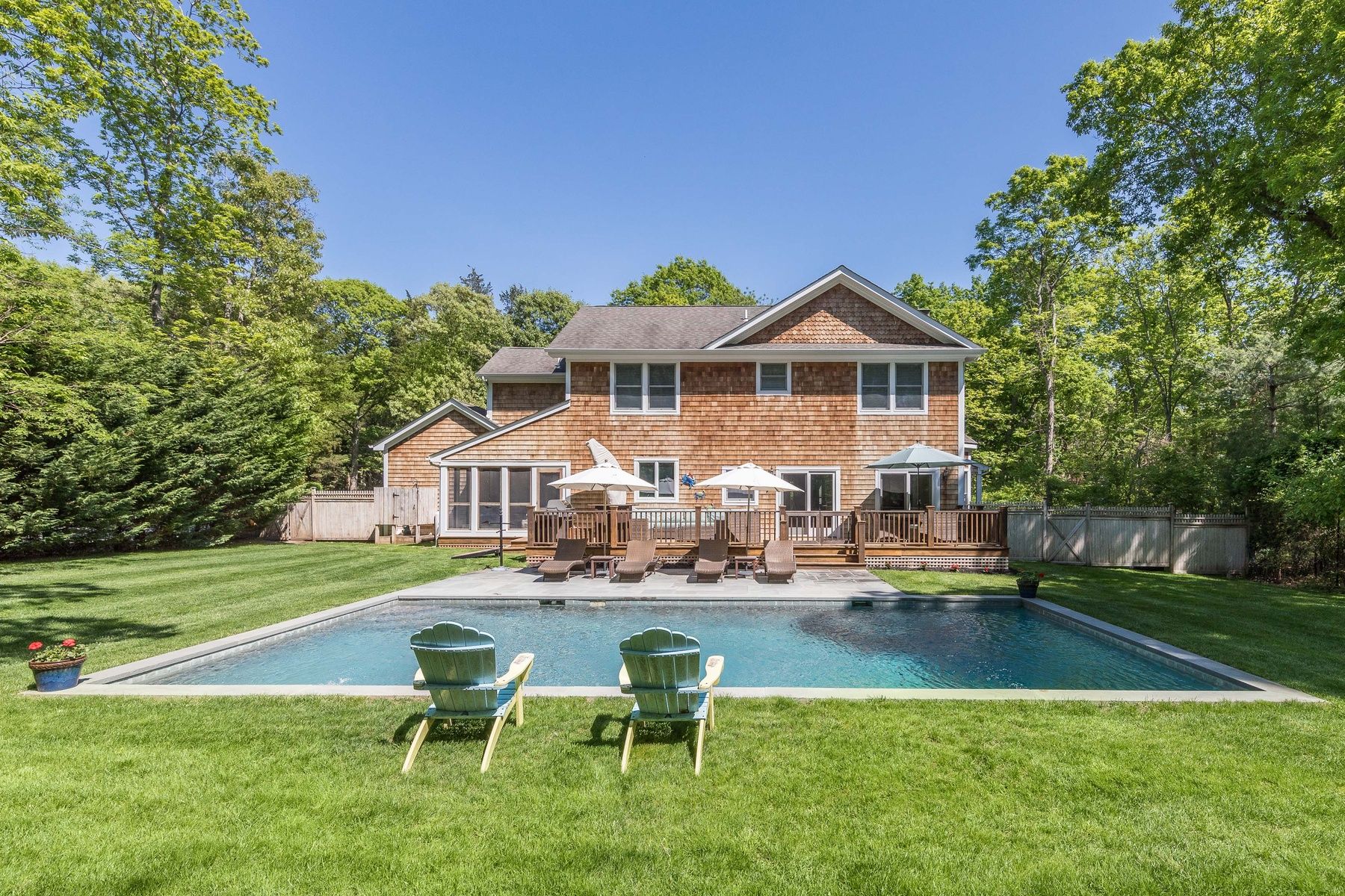 a front view of a house with garden and trees