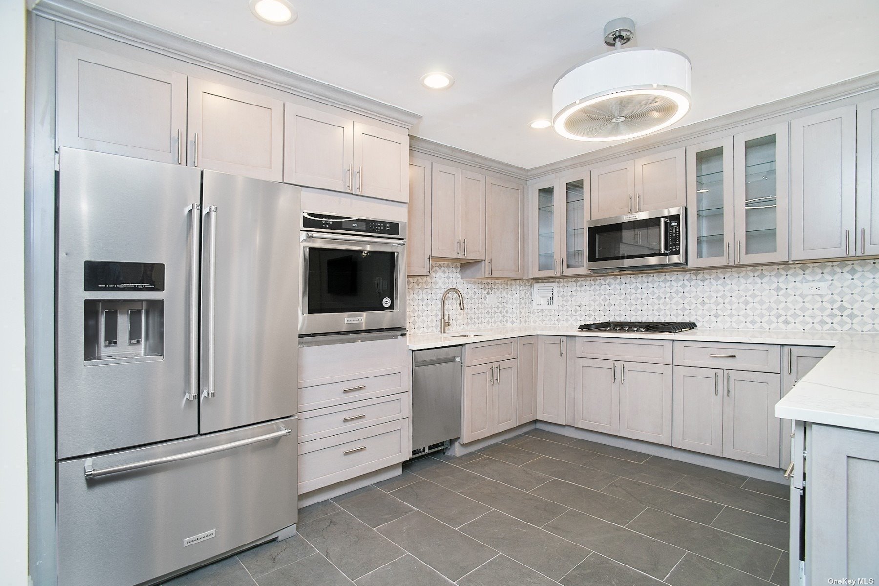 a kitchen with granite countertop a refrigerator stove and microwave