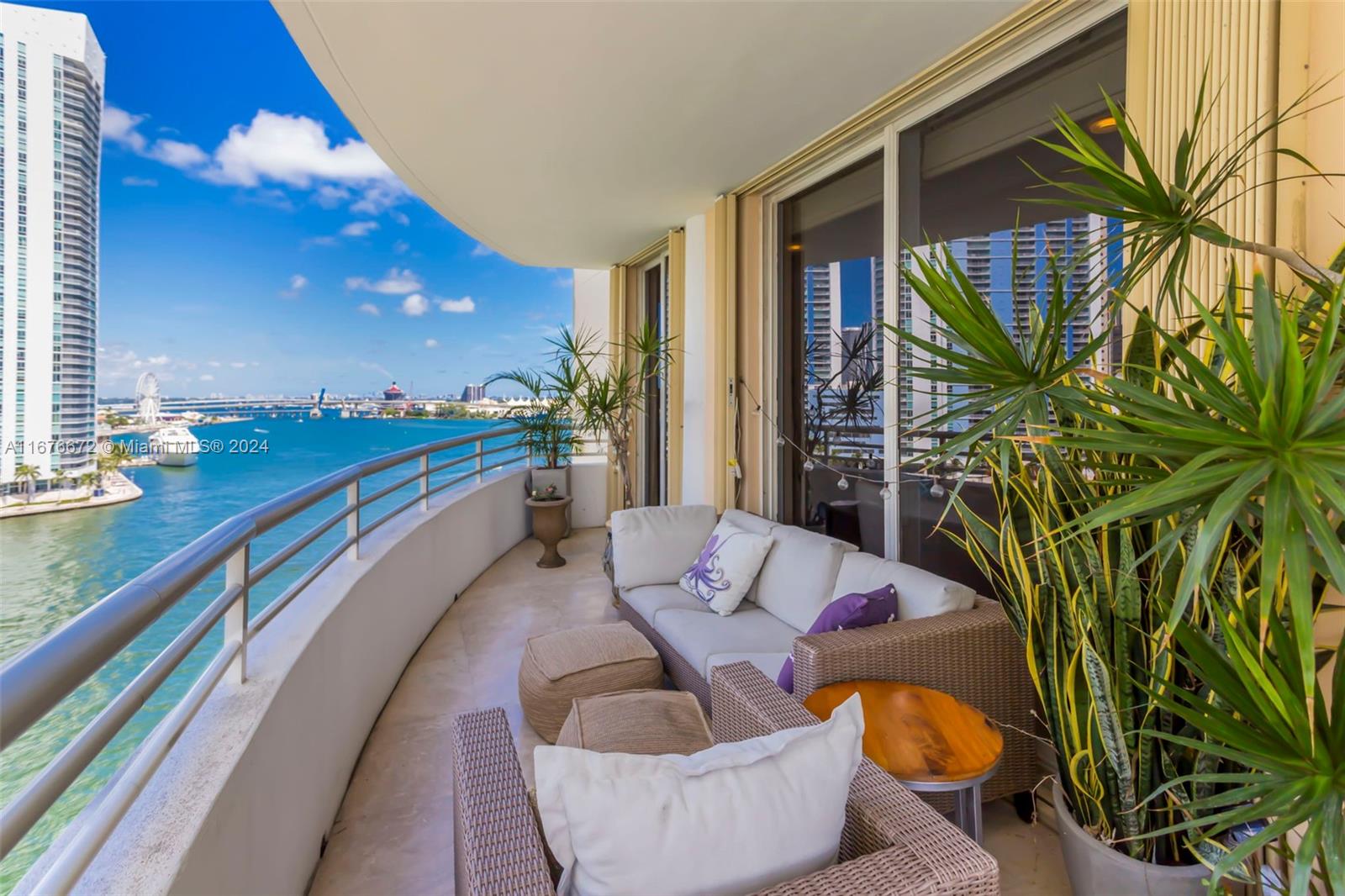 a balcony with chairs and a potted plant