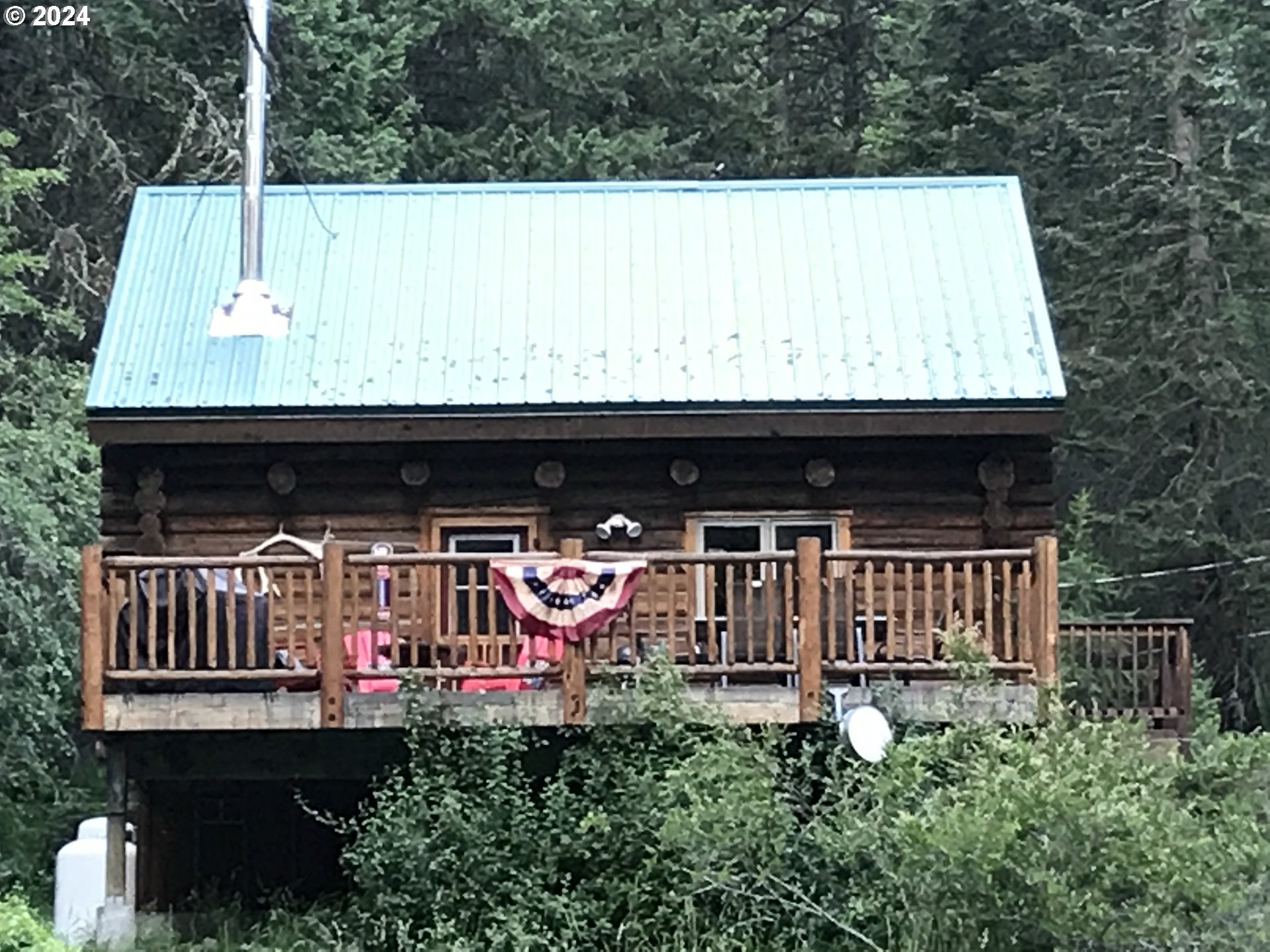 a view of two chairs and table in the back yard of the house