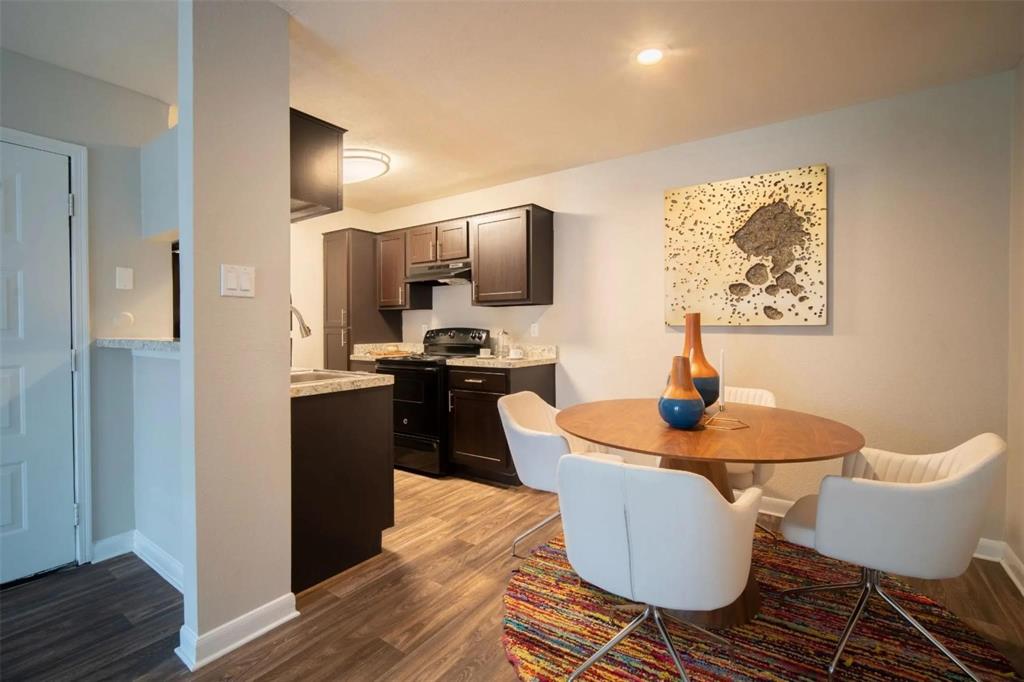 a kitchen with stainless steel appliances kitchen island granite countertop a sink and a refrigerator