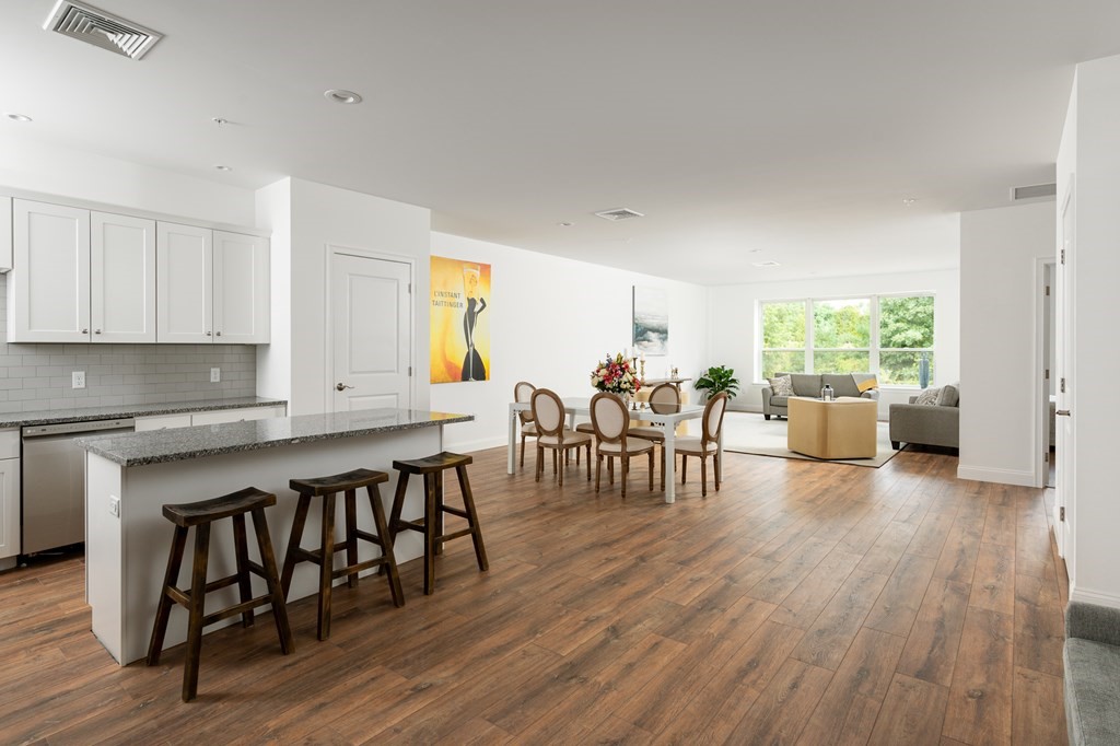 a open kitchen with dining table chairs and wooden floor