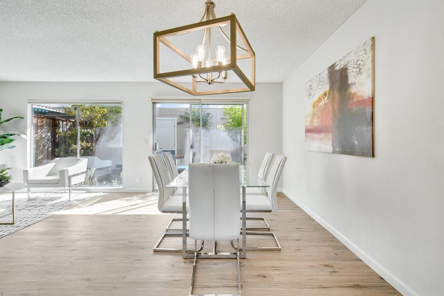 a dining room with wooden floor a glass table and chairs