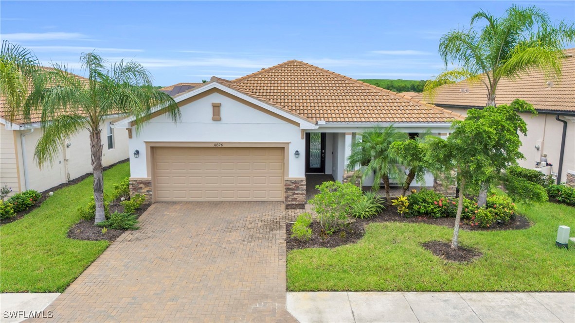 a front view of a house with a yard and potted plants