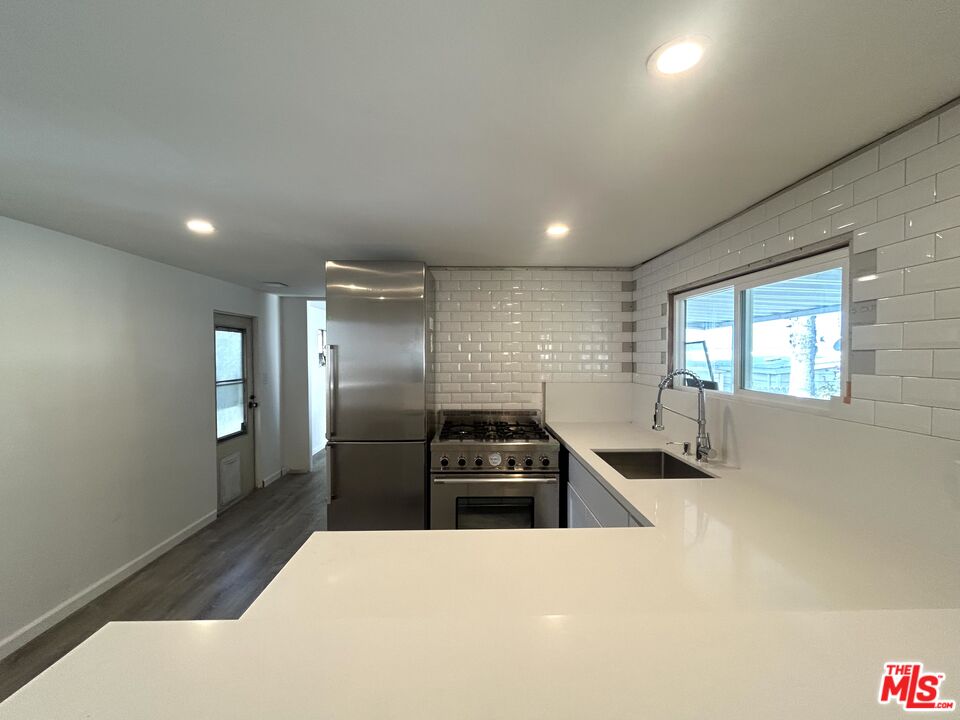 a kitchen with sink refrigerator and window