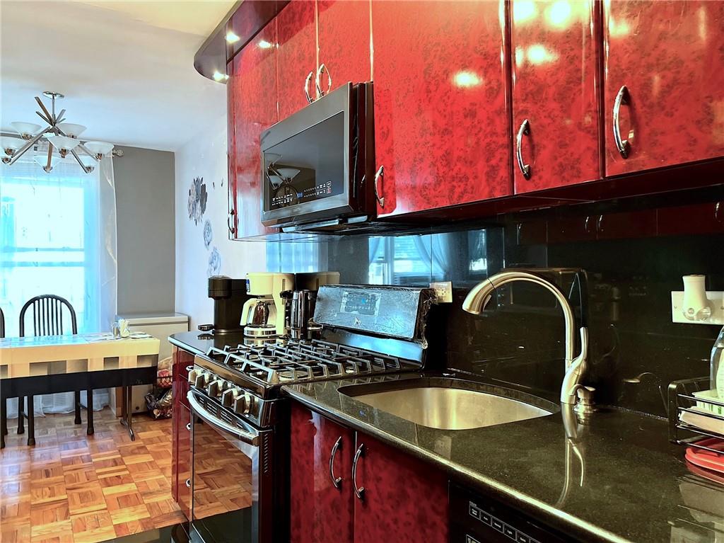 a kitchen with a stove a sink and dining table with chairs