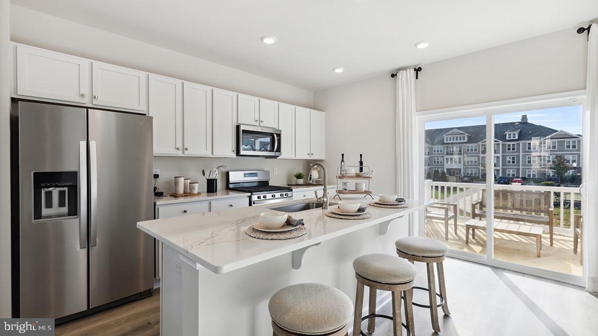 a kitchen with sink a refrigerator and chairs