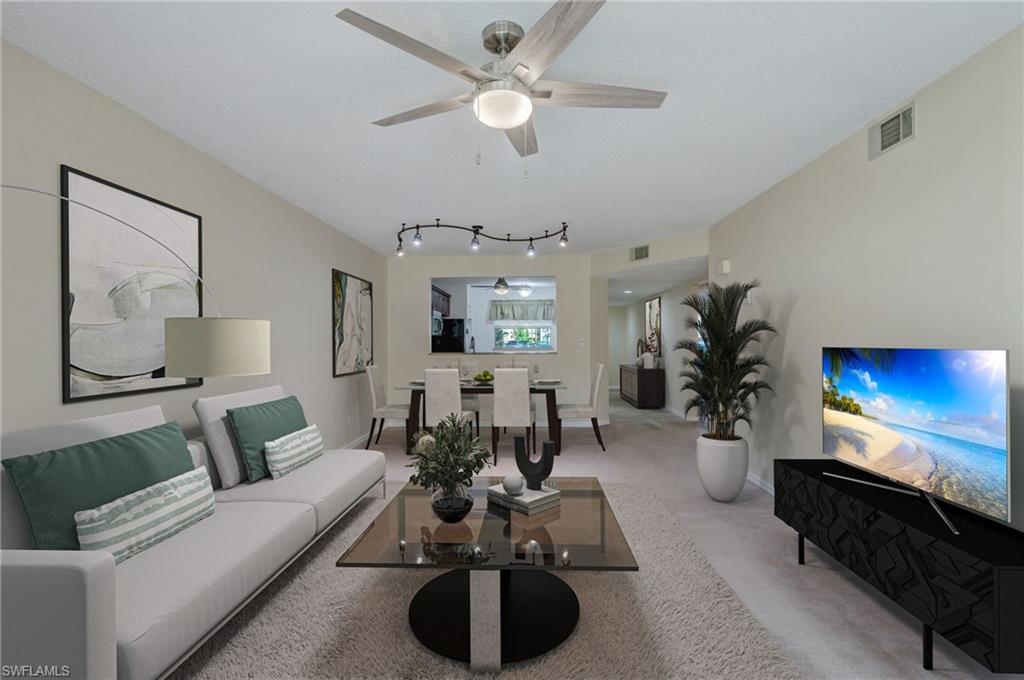 a living room with furniture a chandelier and a flat screen tv