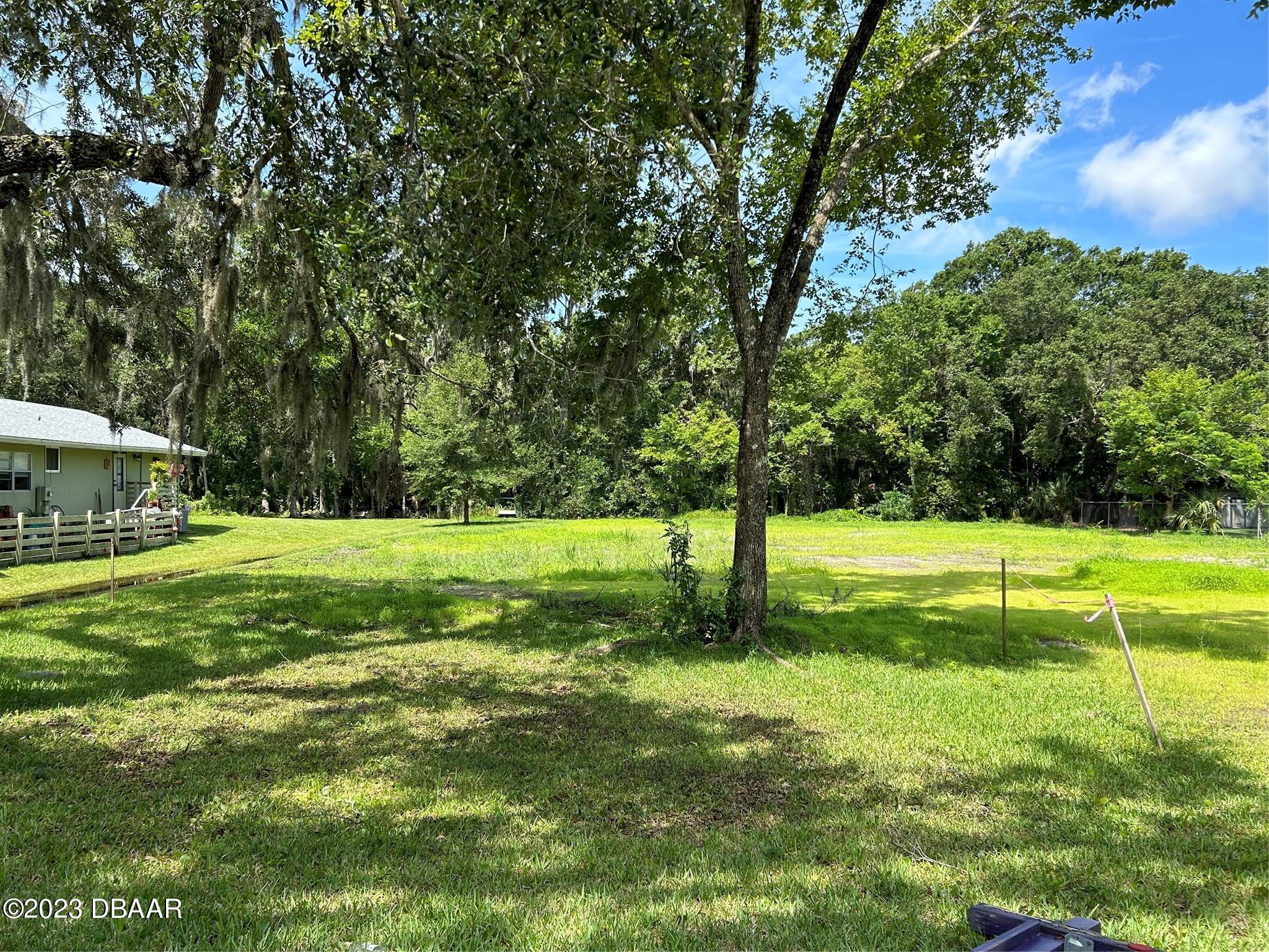 a view of yard with swimming pool and trees