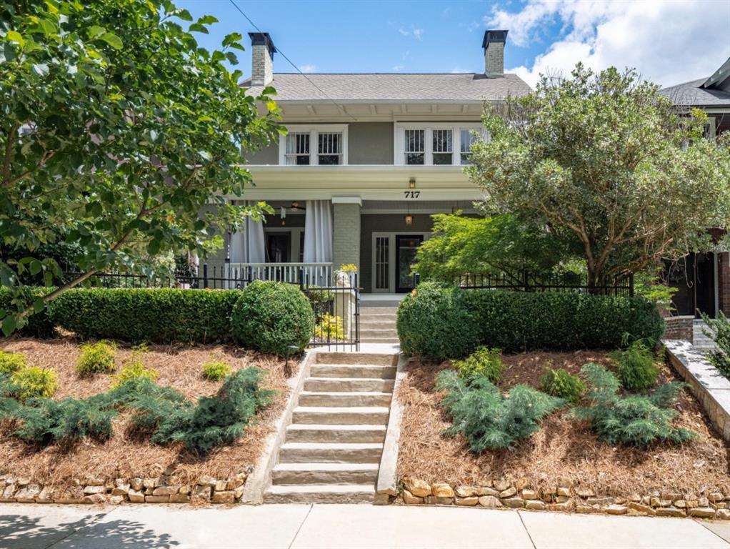 a front view of a house with a yard and potted plants