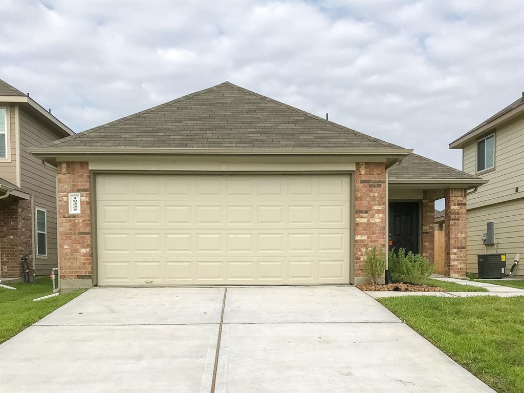 a front view of a house with a garden and garage