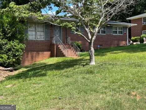 a view of house with a yard