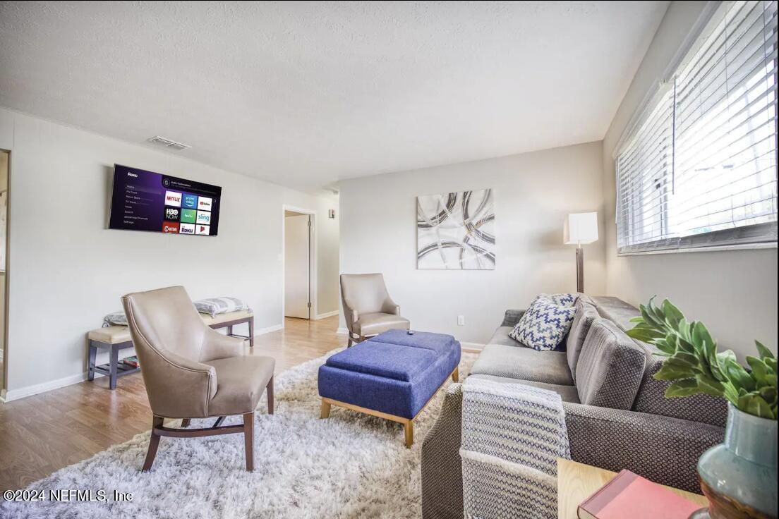 a living room with furniture a rug and a window