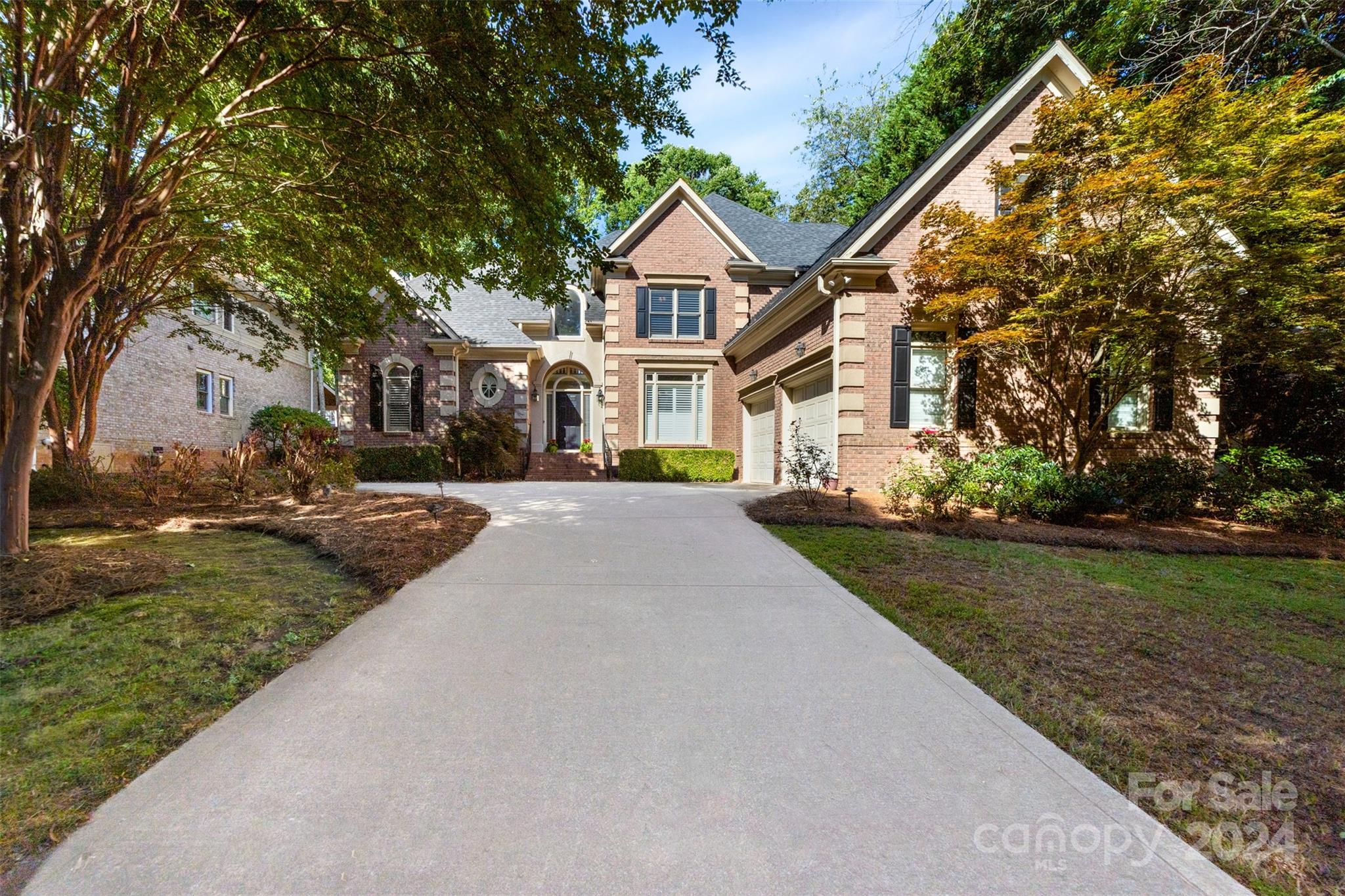 a front view of a house with a yard and trees