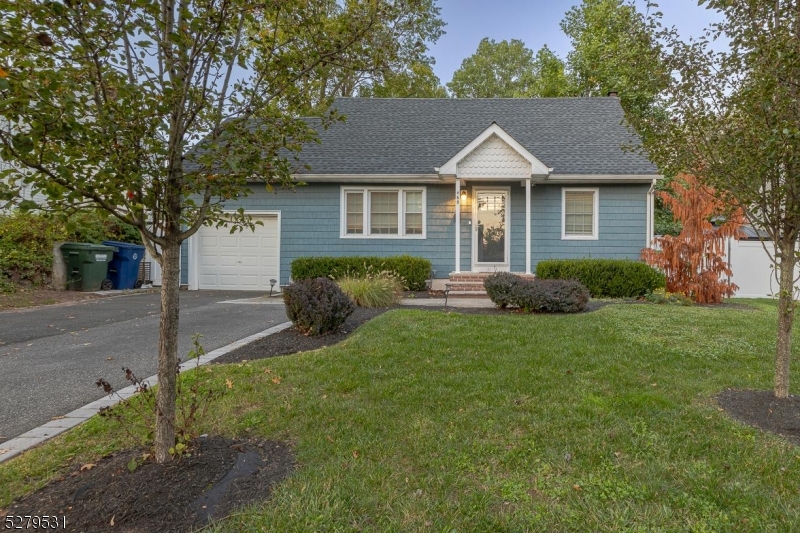 a view of a house with a yard and a large tree