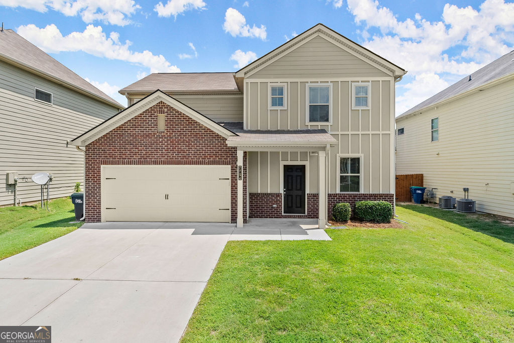 a front view of a house with a yard and garage