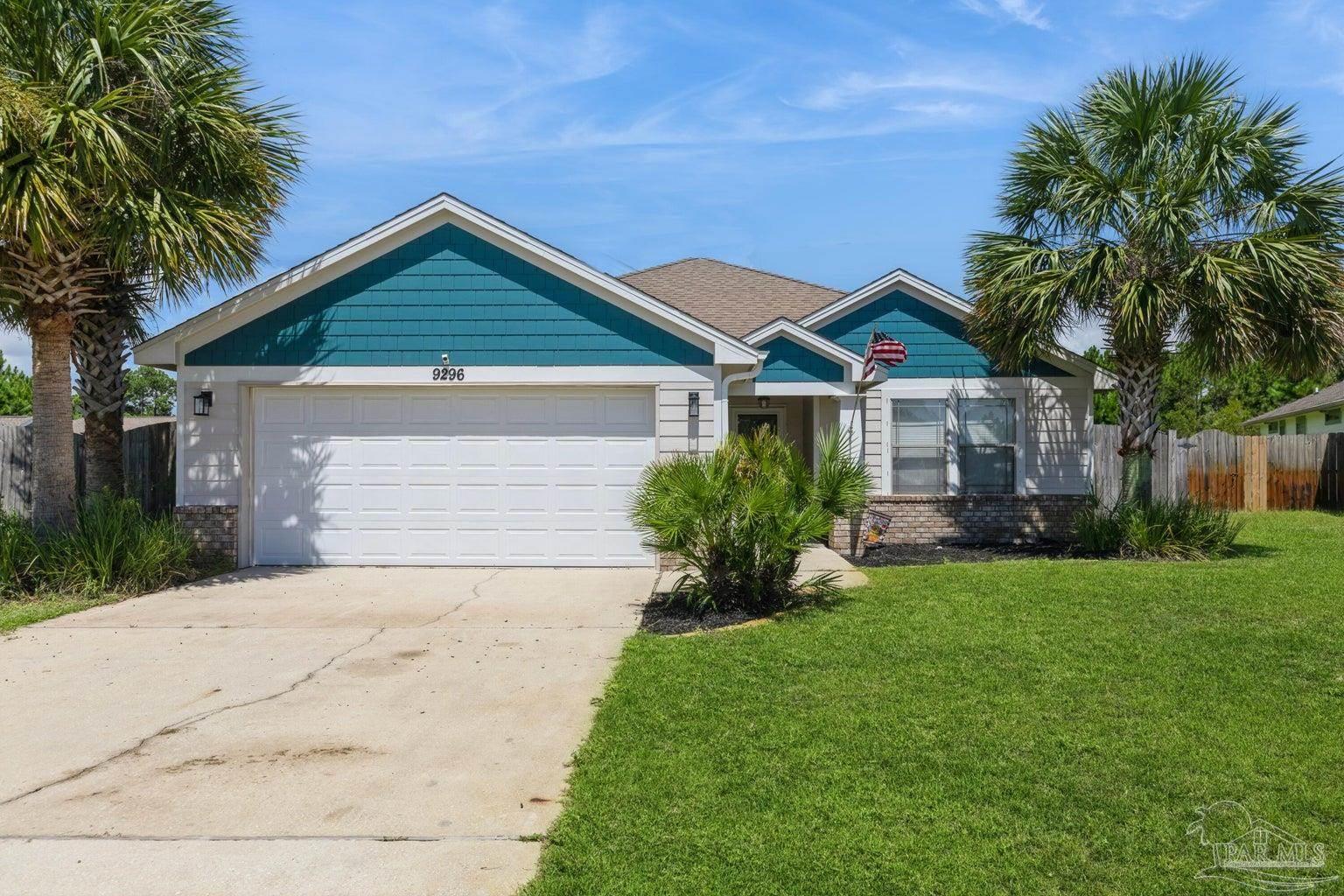 a front view of a house with a garden and palm trees