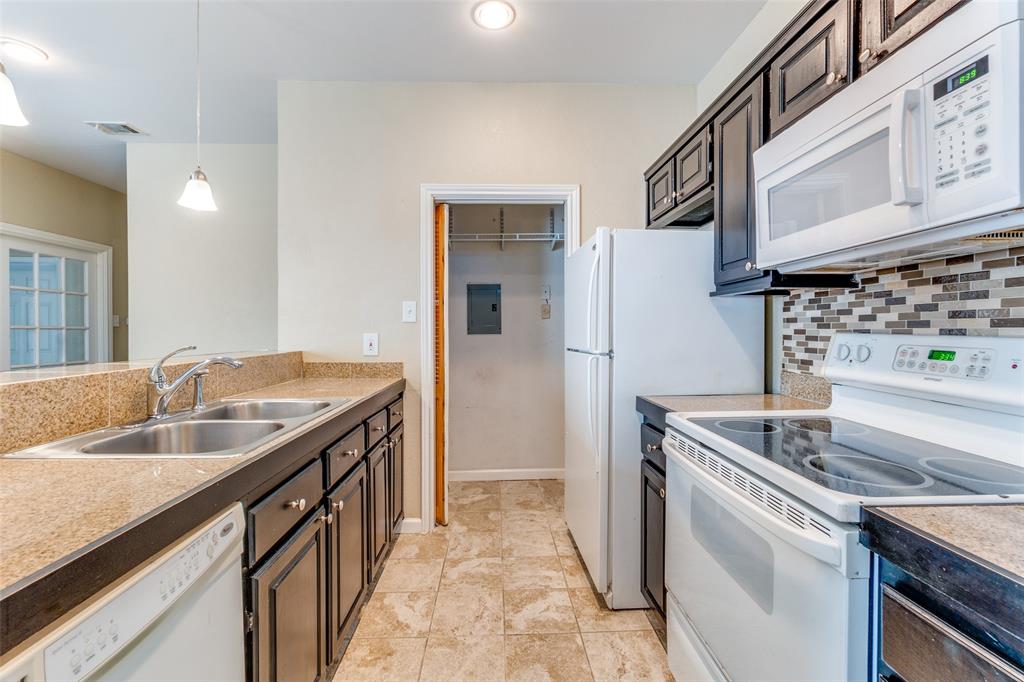 a kitchen with stainless steel appliances granite countertop a sink and a refrigerator