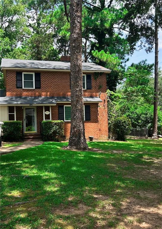 a front view of a house with a yard and trees