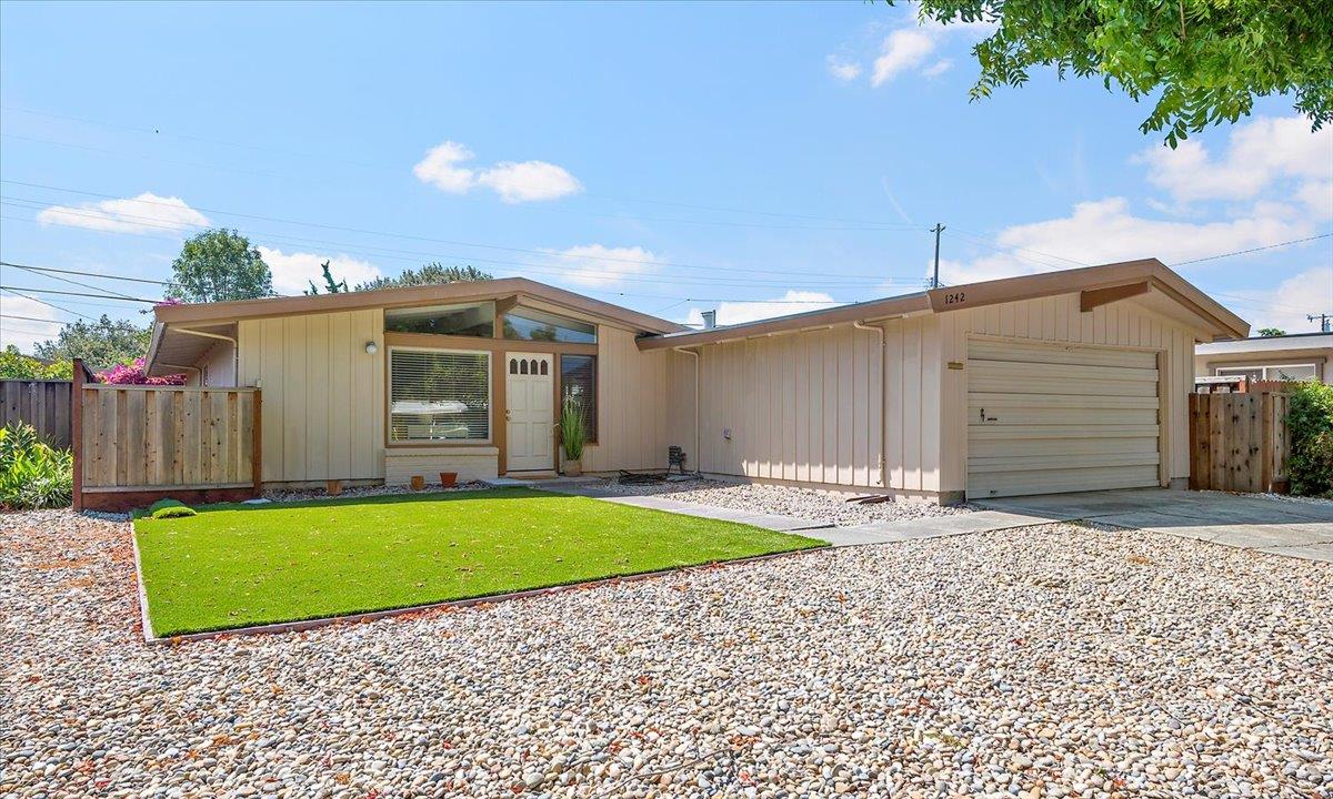 a view of a house with a yard and wooden fence