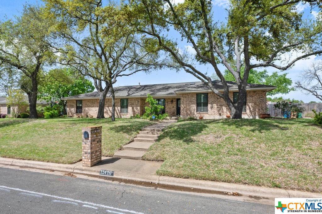 front view of a brick house with a yard