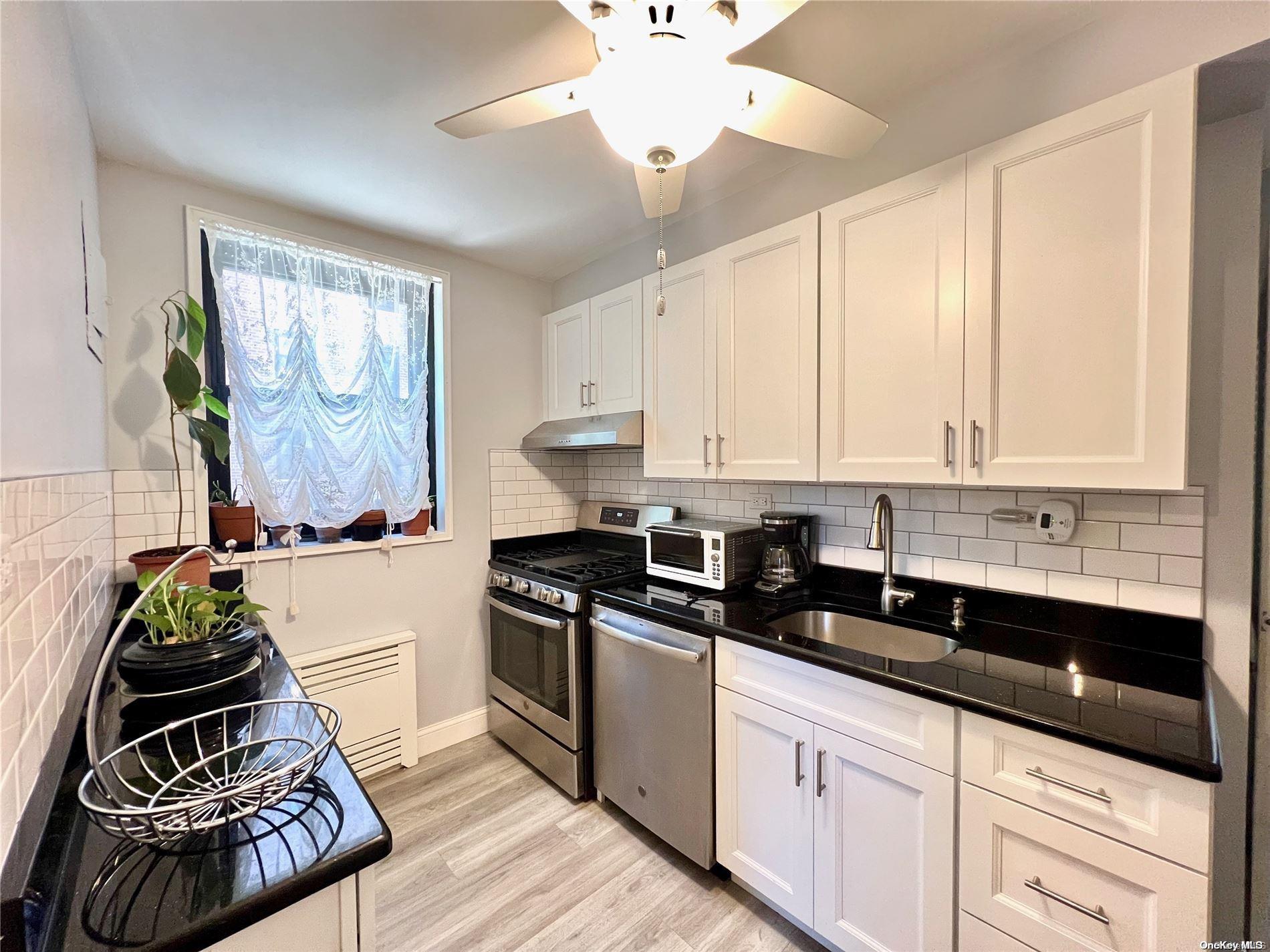 a kitchen with granite countertop a sink a stove and cabinets