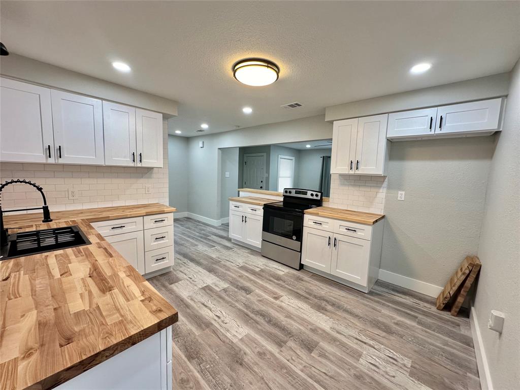 a kitchen with granite countertop a sink stove and refrigerator