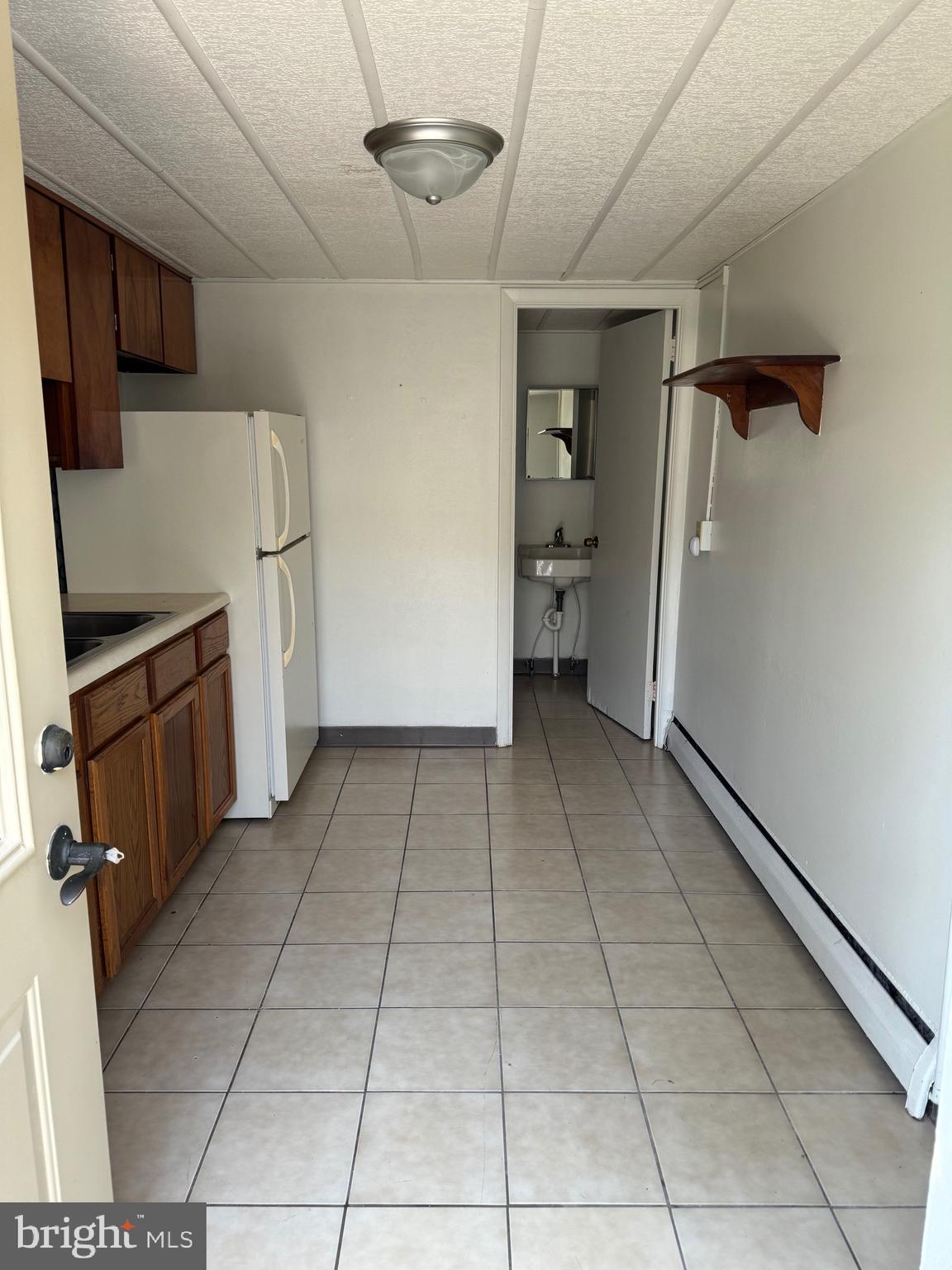 a view of a storage & utility room with refrigerator and washer