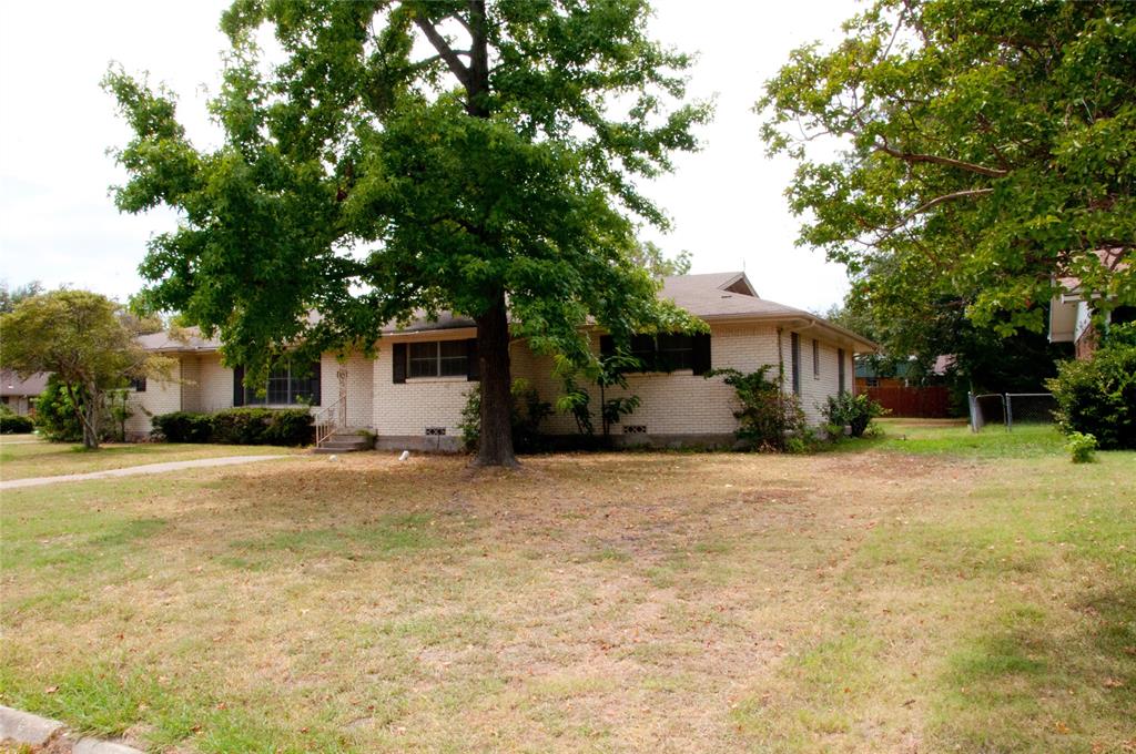 a front view of a house with a garden and tree