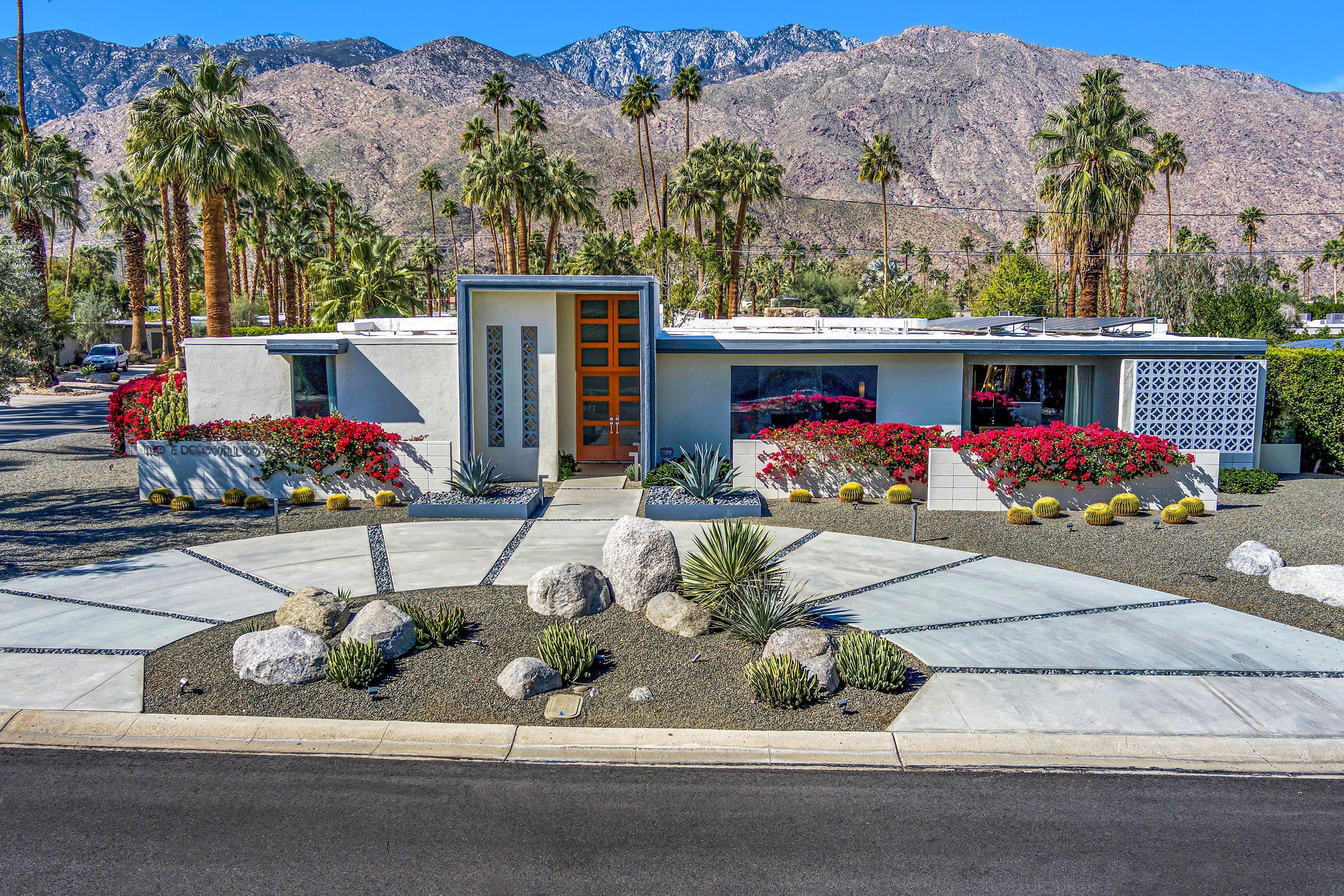 a front view of house with lot of flowers